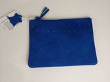le petit sac à main bleu est posé sur une table blanche, avec une étiquette