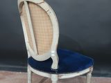 an antique chair with a blue velvet seat and a wooden frame