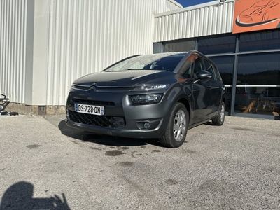 La voiture est garée devant un immeuble devant lequel est garée une moto.