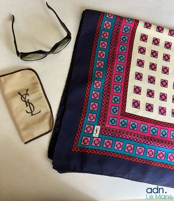 un sac à main, des lunettes de soleil et une écharpe posés sur une table