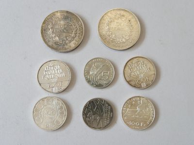 Plusieurs pièces différentes sont disposées en rangée sur une surface blanche