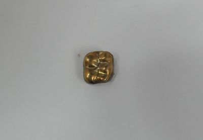 a gold plate with a small square shaped object on top of it