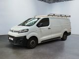 the white van is parked in a large room with a light on