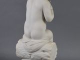 an image of a statue of a child sitting on top of a rock