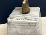 statue of a cat sitting on a marble block with writing on it
