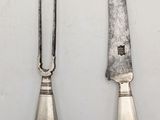 two knives and a fork on a table with a white background