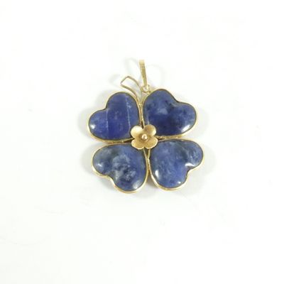 une image montrant un gros plan d'un pendentif en forme de fleur bleue sur fond blanc