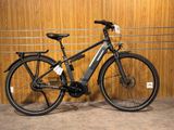 un vélo noir garé dans un garage, à côté d'un mur en bois