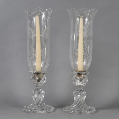 pair of clear glass candlestick holders with gold accents on each of them