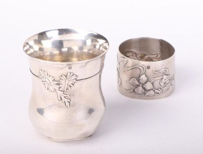 a silver cup sitting next to a silver cup on a table