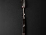 a fork with a heart on it on a black background