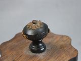 a black knob on top of a wooden table