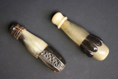 deux pièces en ivoire sculpté et en verre noir posées sur un fond noir