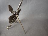 a metal sculpture of a man holding a knife and a spear