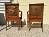 two wooden chairs sitting next to each other on the sidewalk