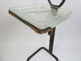 un plateau en verre posé sur un support métallique, sur fond blanc