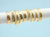 three gold rings on a white cloth with a blue background