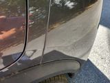 a man taking a picture of his reflection in the side of a car