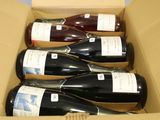 plusieurs bouteilles de vin se trouvent dans un carton sur une table