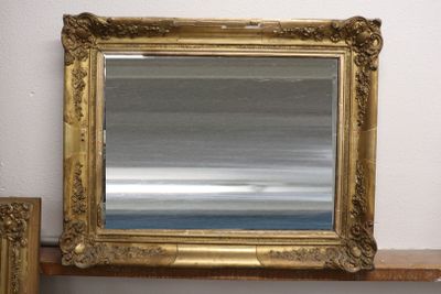 un miroir posé sur une étagère, à côté d'un miroir accroché au mur