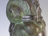 sculpture of a woman ' s head wearing a green and black headdress
