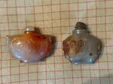 deux flacons en verre posés sur une table recouverte d'une nappe à carreaux