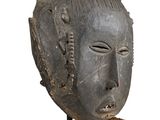 an image of a wooden mask with spikes sticking out of it ' s face