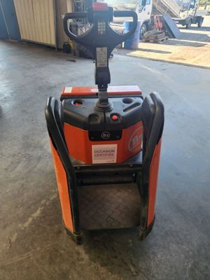 un chariot élévateur orange et noir garé dans un garage