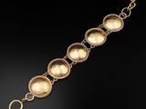 a gold bracelet with five circles and a circular clasp