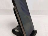 a close up of a cell phone on a stand on a white surface