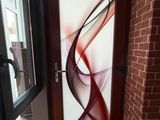 une porte vitrée ornée d'une peinture, à côté d'un mur de briques