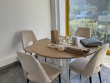 une table et des chaises dans une pièce avec une grande fenêtre
