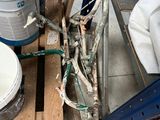several buckets of paint sitting on top of a pallet next to a pile of wood
