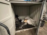 un chien qui se trouve à l'intérieur d'un conteneur dans le garage