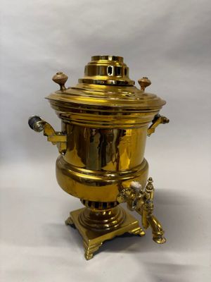 cafetière en laiton plaqué sur son socle, sur fond blanc