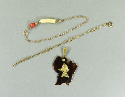 un collier plaqué or orné d'un ours et d'une banane