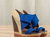 the wedged sandal is blue and has two straps on each side