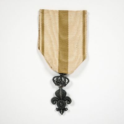 une médaille d'or à laquelle est accroché, sur le côté, un ruban noir et blanc