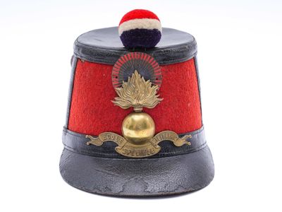 un chapeau rouge orné d'une clochette dorée