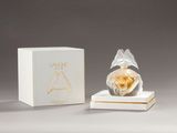 a small perfume bottle sitting on top of a white box