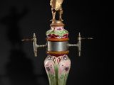 a vase with a statue on top of it on a black background