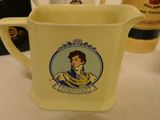 a yellow pitcher with a picture of a woman on it