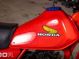 a close up of a red honda motorcycle parked in a garage