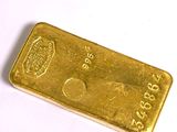 gros plan d'un lingot d'or sur une surface blanche