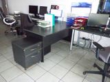 a desk with two computers and a chair in a room