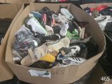 plusieurs paires de chaussures dans une boîte en carton posée sur le sol