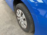 a close up of a blue car parked in a parking lot
