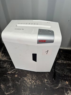 the paper shredder is sitting on the floor next to the wall