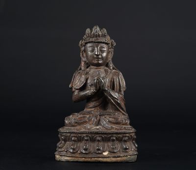 une statue en bronze représentant un Bouddha sur fond noir