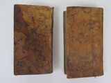 pair of antique leather bound books on a white surface